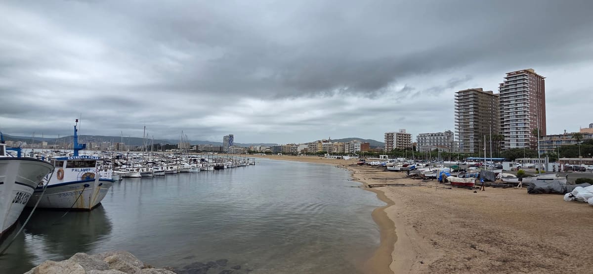 The harbour at Palamós on an overcast afternoon, fishing boats moored along the quay